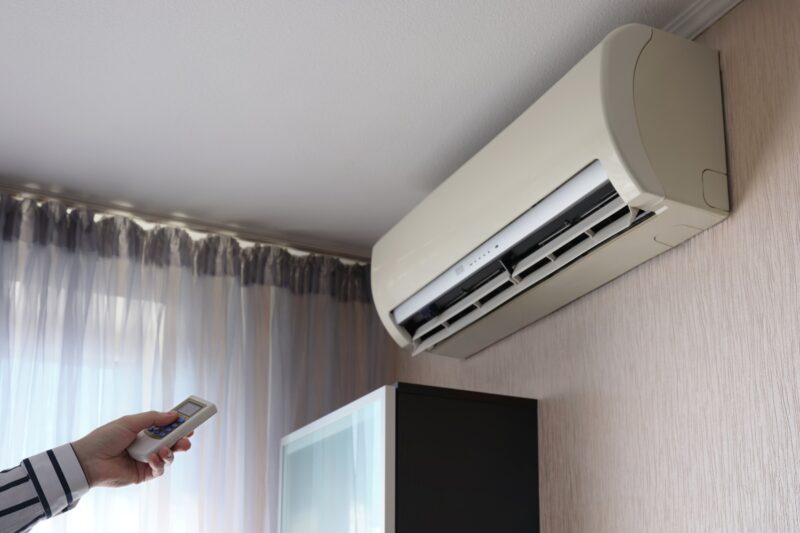 osoba pokušava da upali klimu sa daljinskim upravljačem