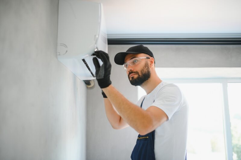 prikaz momka koji popravlja klimu